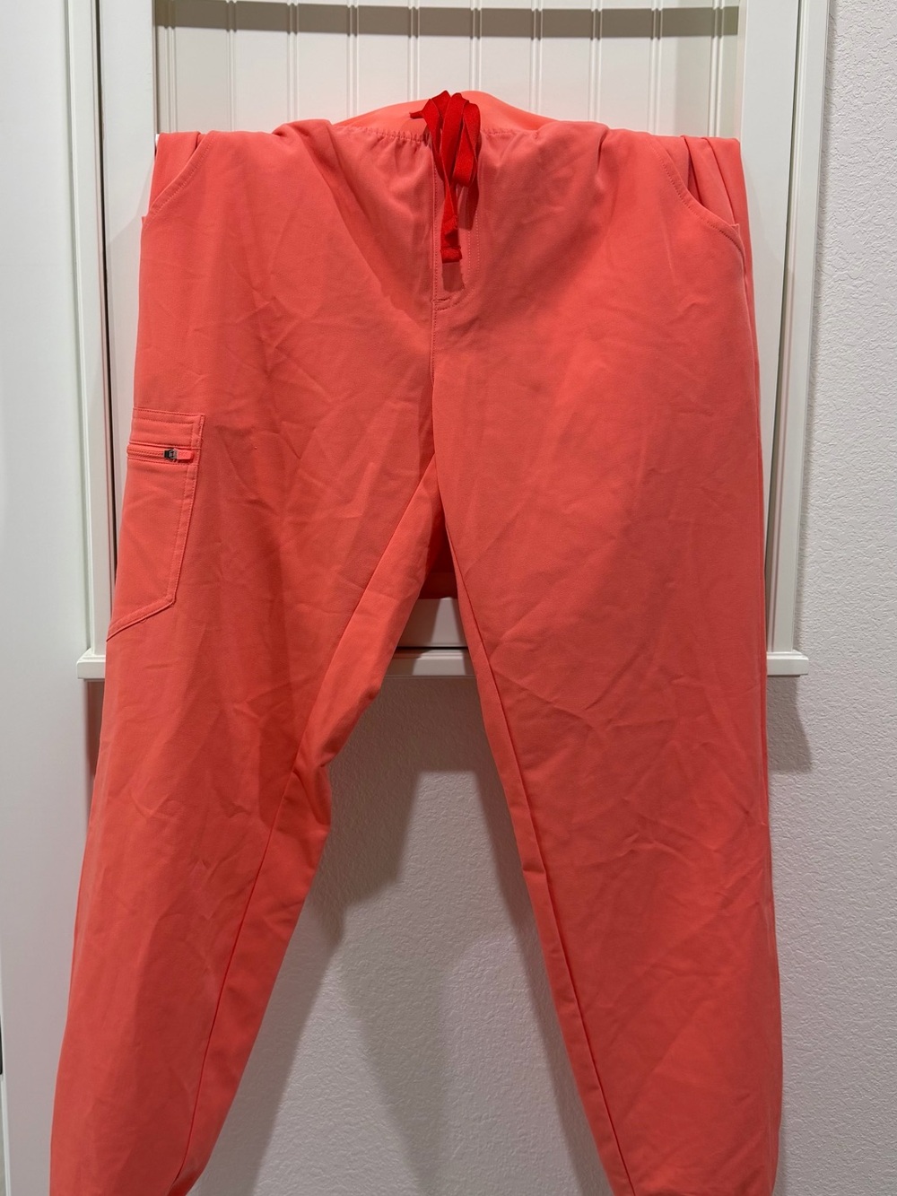 Women’s M/T FIGS Zamora Jogger scrub pants in a bright coral-red